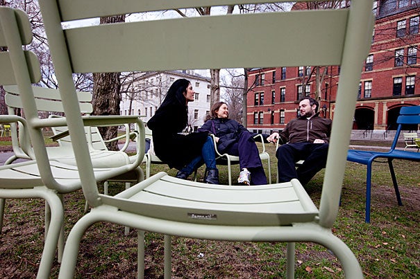 Carina Cappello (from left), Caroline Psutka, and Christopher Mejo relax in the colorful chairs recently returned to Harvard Yard.