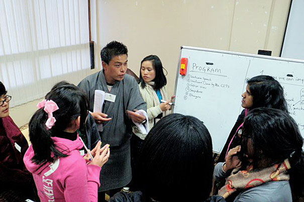 A trainer takes lead in a discussion with Harvard volunteers working with Bhutanese youth.