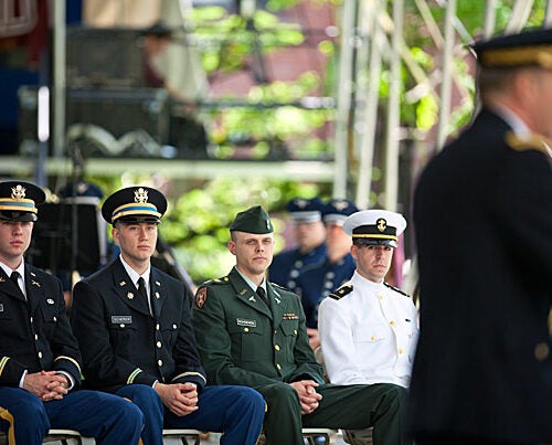 Maj. Gen. James C. McConville (at podium) was the keynote speaker at the ROTC commissioning ceremony. Christopher Higgins (from left) and Aaron R. Scherer, both 2nd lieutenants in the Army, and Navy Midshipman James D. Reach (far right) were commissioned. Cadet Michael Schoenen will take his oath as an officer when he completes his A.L.M. thesis at the Harvard Extension School.