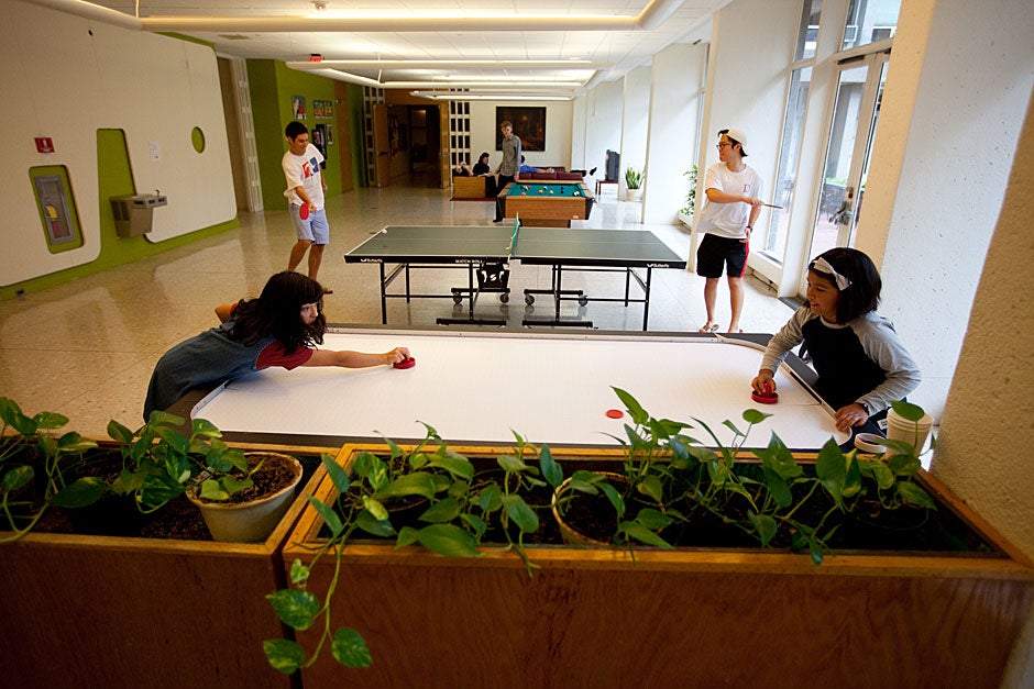 Mara (left) and friend Autumn play air hockey while Currier students play ping-pong in the lower level lounge. Rose Lincoln/Harvard Staff Photographer