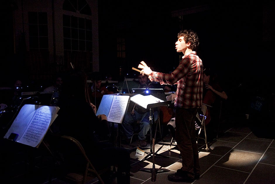 Music director Matt Aucoin '12 conducts the orchestra during a rehearsal. Jon Chase/Harvard Staff Photographer