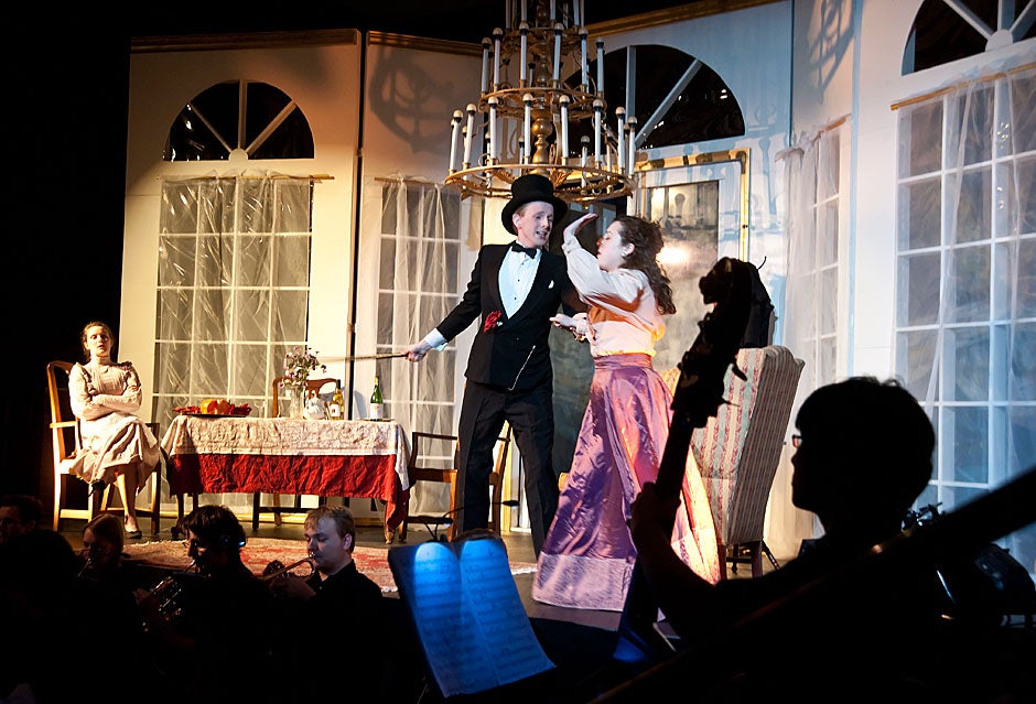 Framed by a bass player in the orchestra, the Dunster House Opera Society performs Johann Strauss’ “Die Fledermaus” with Ben Nelson '11 and Bridget Haile '11 in the lead roles at center stage. Jon Chase/Harvard Staff Photographer