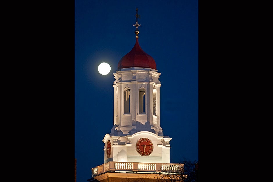 A full moon rises behind the Dunster House tower. Jon Chase/Harvard Staff Photographer