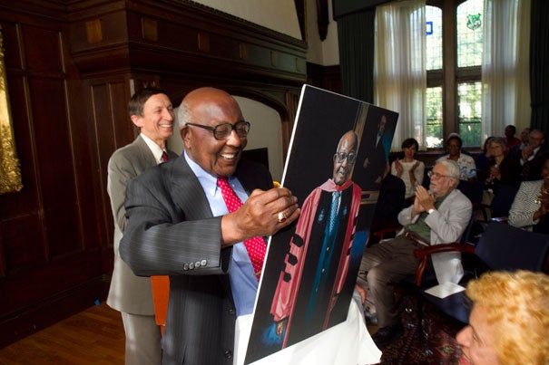 Preston N. Williams, Houghton Research Professor of Theology and Contemporary Change Emeritus at Harvard Divinity School, unwraps a portrait of himself produced as part of the Harvard Foundation's Portraiture Project.