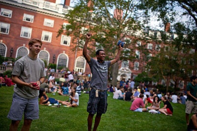 Ben Enowitz '12 (from left) and Wes Mann '13 play "cornhole" on the lawn during Eliot House's welcome back barbecue. 