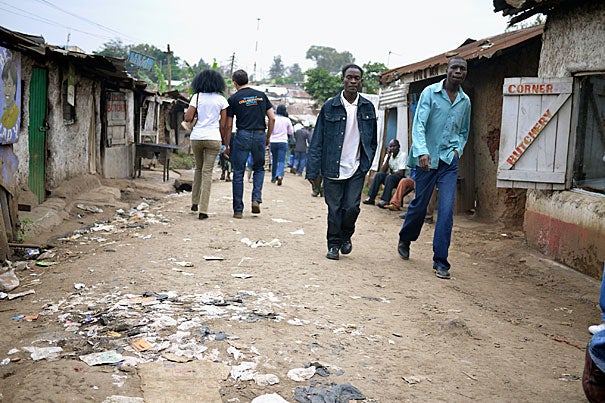 Rye Barcott (back to camera, right) along a corridor in Kibera's busy D.C. village. Barcott, along with two Kibera friends, founded Carolina for Kibera, a nonprofit that in July celebrated its 10th anniversary of intertribal soccer, female empowerment, trash collection, reproductive health education, and community medicine. 