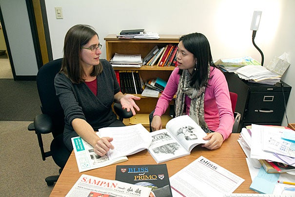 Nicole Newendorp (left) and her new Behavioral Laboratory in the Social Sciences (BLISS) research fellow Debra Chang look over  materials relating to a  summer research program at her office in Hilles.
