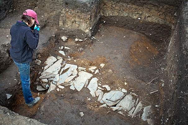 Christina Hodge takes photos where late last week students enrolled in “The Archaeology of Harvard Yard” uncovered what looked like a stone path.