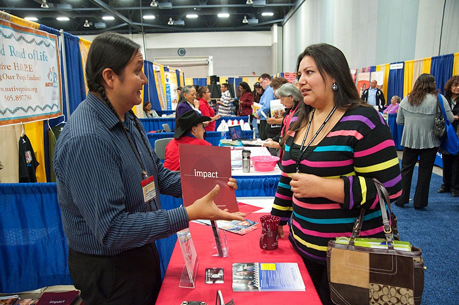 At the National Indian Education Association conference, Jason Packineau speaks with a woman inquiring about graduate school. Jon Chase/Harvard Staff Photographer