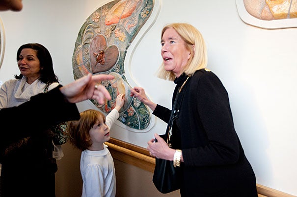 Artist Pam Ward (right) introduced her neighbor's granddaughter, Clara Marttila, age 5, to her art when collaborative murals were unveiled at Cambridge Health Alliance. Ward, and others, are part of the Ceramics Program at Harvard's Office for the Arts.   