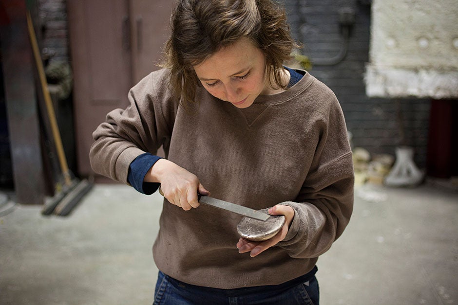 Metal files are used to remove casting imperfections and smooth any rough areas. Graduate student Caitlin Henningsen cleans up her piece. 
Stephanie Mitchell/Harvard Staff Photographer
