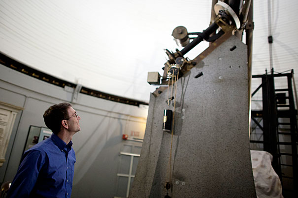 Astronomy Professor Daniel Eisenstein has devised a new method to determine the position of galaxies and is using that to understand how
the universe works. Here, Eisenstein looks at Harvard's Great Refractor,
installed in 1847 and for 20 years the largest telescope in the country.