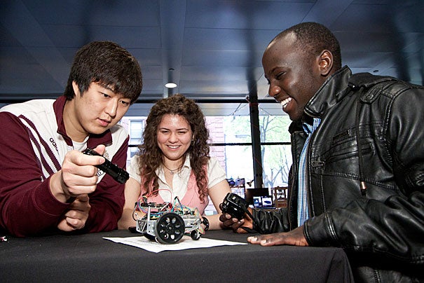 Gye Hyun Baek '13 (from left) and Madalina Persu '13 exhibit their ES 50 project with course assistant Leonard Kogos '12. They created what appeared to be a self-propelled four-wheeled vehicle, but was in fact powered by a handheld laser pointer. 