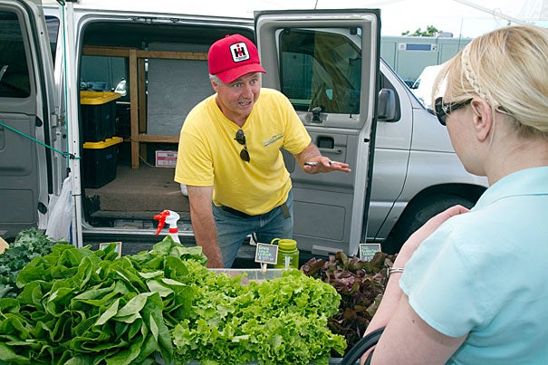 Frank Ventura of Dragonfly Farms speaks to a customer at the Harvard Allston Farmers' Market, which kicked off the season last week and will continue running Fridays, 3-7 p.m. The Cambridge market takes place Tuesdays from noon to 6 p.m. in front of the Harvard Museum of Natural History.
