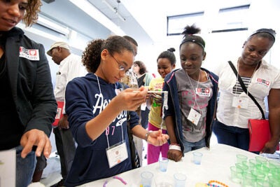 Michelle Tapia (from left), Brianna Valbrun (in yellow shirt), and Rachelle Brown-Mitchell, all of the  E. Greenwood Leadership Academy, participated in a Harvard 2012 Step UP/Project TEACH event, which hosted students and families from the Hennigan Elementary School and the E. Greenwood Leadership Academy for a college readiness program at Harvard's Science Center. 