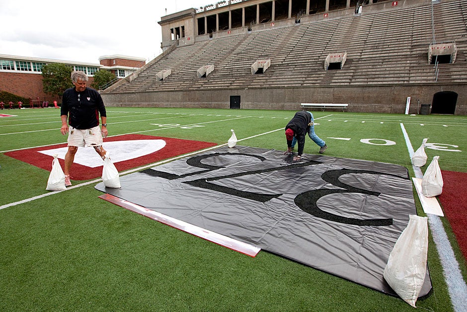 Workers paint 375 on the turf at Harvard Stadium to celebrate the University's 375th anniversary. Rose Lincoln/Harvard Staff Photographer