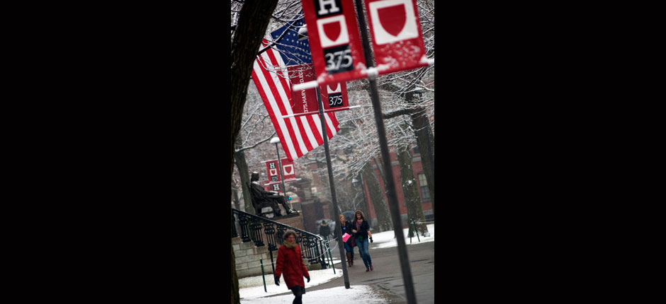 Snow falls on the John Harvard Statue while 375th signs decorate Harvard Yard. Kris Snibbe/Harvard Staff Photographer