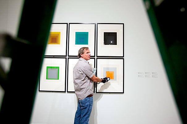 Edward Lloyd, exhibitions manager at the Carpenter Center, checks the lighting on a series of works by Josef Albers, "Homage to the Square," which are included in "circa 1963." The exhibit features works by 15 artists in vogue during the years of vinyl dinette sets, the Kennedy White House, and airplanes with ashtrays.
