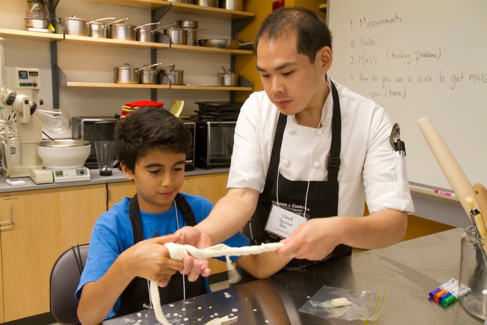 Harvard hosts a two-week Science and Cooking course for Cambridge and Boston students as part of its summer learning series, bringing in top chefs from Boston and Cambridge as well as graduate students and professors from Harvard.  Jason Doo (right) assists Kays Laouar, 11, in pulling string cheese into the proper shape. Jon Chase/Harvard Staff Photographer