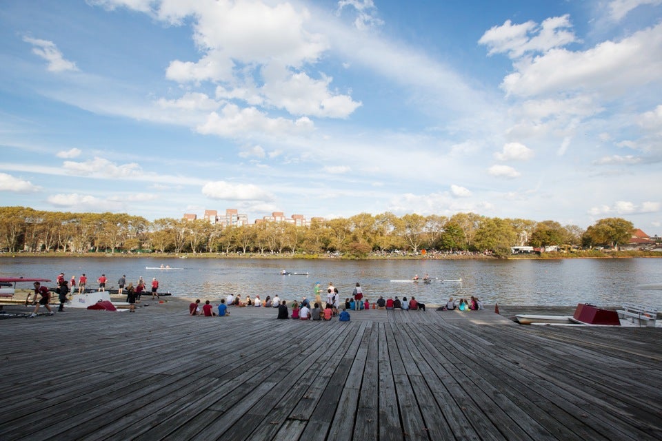 Spectators watch the Head of the Charles Regatta from the Newell Boat House dock. Harvard competed in a majority of the races on both days of the event, with participation by students, parents, alumni, and staff.