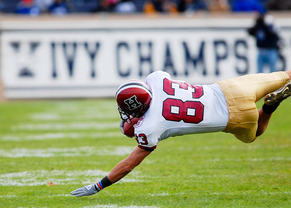 Harvard wide receiver Corey Mazza '08 makes an acrobatic catch — against a winning backdrop — while bracing his fall with one hand during the game in 2007.