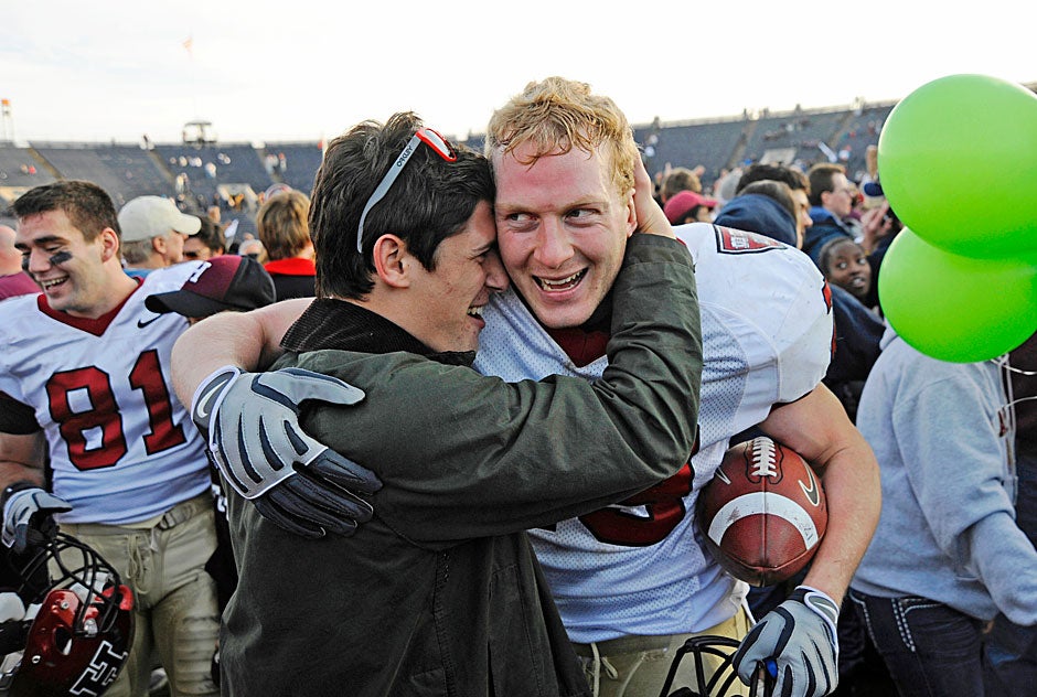 Crimson linebacker Conor Murphy '10 receives a well-deserved hug at game's end in 2009. Murphy holds the ball he recovered from a Yale fumble that ensured the victory as the clock wound down. Wide receiver Adam Chrissis '12 is at left. 
