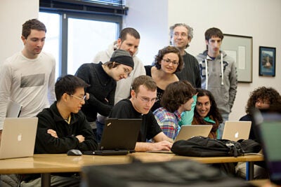 David Fan and Bob Adolf (left and center, seated at laptops) were second-place finishers in the IACS Computational Challenge.  For the final challenge, students were tasked with designing a program to play foosball. 