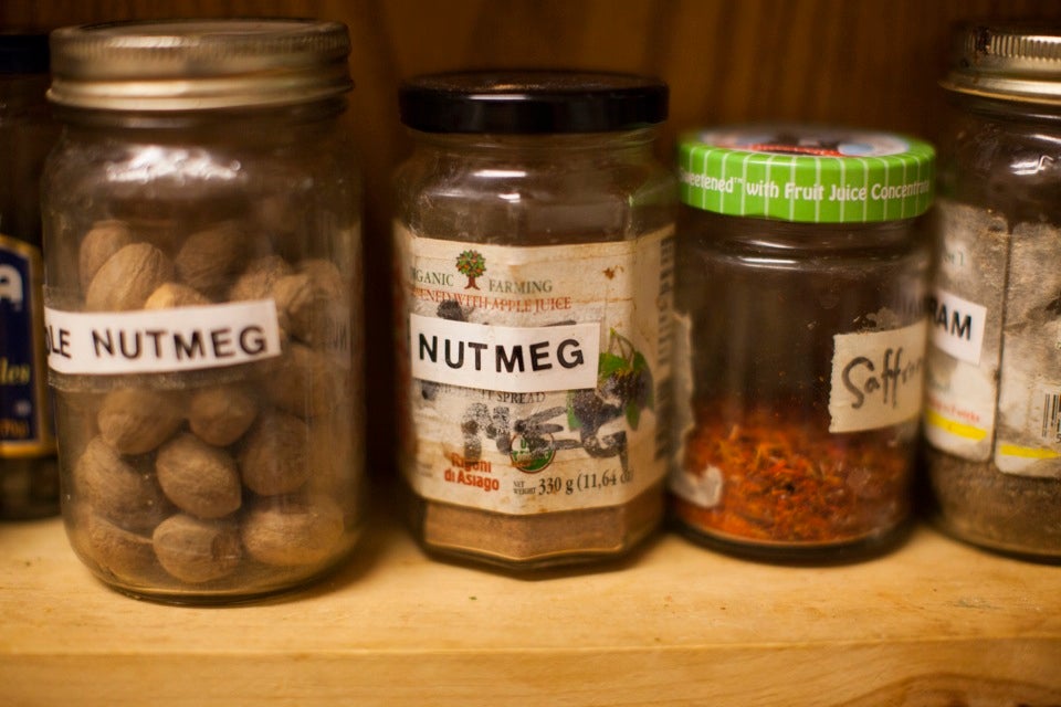 In the kitchen, spices and herbs line the shelves in an eclectic mix of recycled bottles.