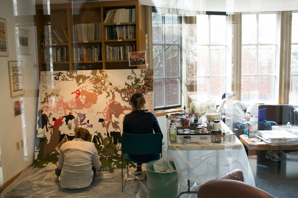 Gilon (right) and Elena Hoffenberg '16 paint inside Harvard Hillel — the project was routed indoors due to inclement weather.