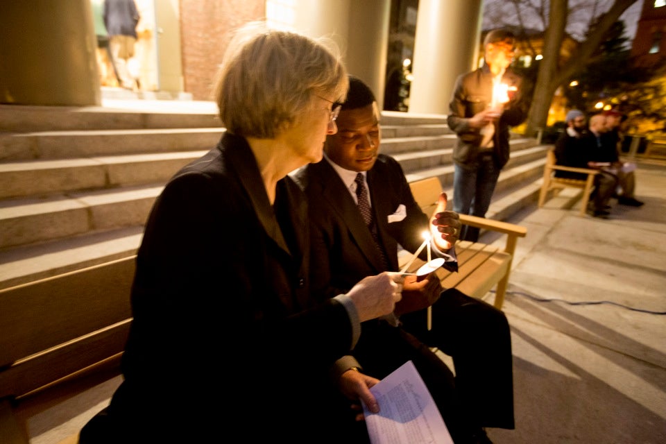 President Drew Faust and Pusey Minister Jonathan Walton light candles at the Tuesday night vigil.