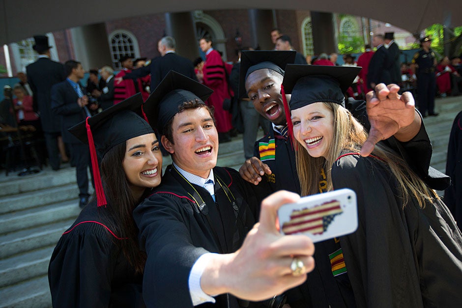 Nadia Farjood (from left), Jose Villanueva, Everton Blair, and Margot Leger take a “selfie” to remember Commencement forever. Kris Snibbe/Harvard Staff Photographer