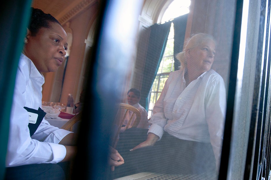 Marie Gerard (from left) and Joan Arruda watch graduates process past a window in Leverett House in 2012. Rose Lincoln/Harvard Staff Photographer