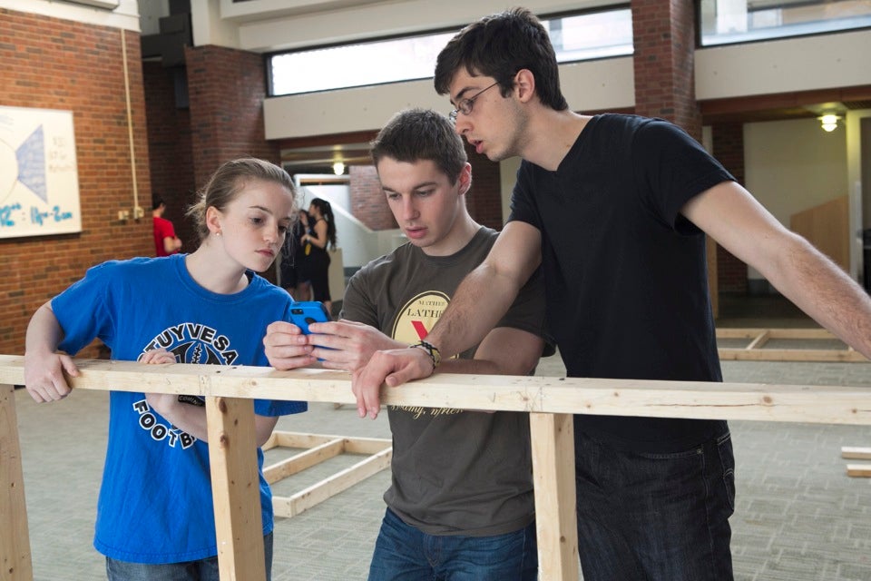 Ella Gibson ’14 (from left), Max Shayer ’14, and Renzo Lucioni ’14 work on building the structure to house the 11th annual Mather Lather foam party.