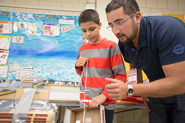 SEAS research and education specialist Jorge Pozo works on a presentation with Juan Nazario at the Hennigan Elementary School in Jamaica Plain. 