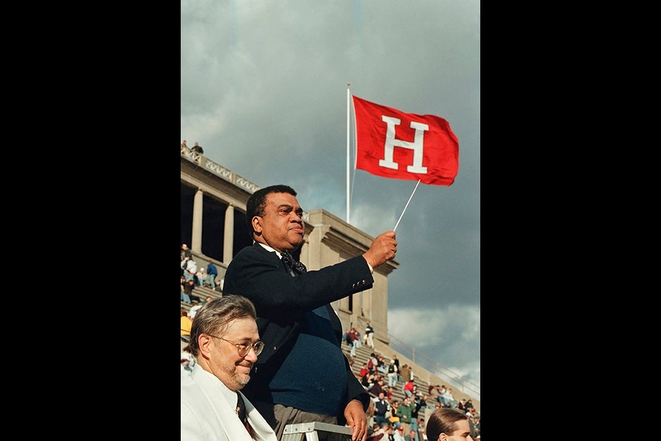 Archie Epps, Harvard College dean of students, conducts the Harvard University Band during half time at the Harvard-Yale football game in 1998, as band director Tom Everett looks on. Epps served as dean for 28 years, while Everett has been the longest serving director of the Harvard University Band since coming to Harvard in 1971.