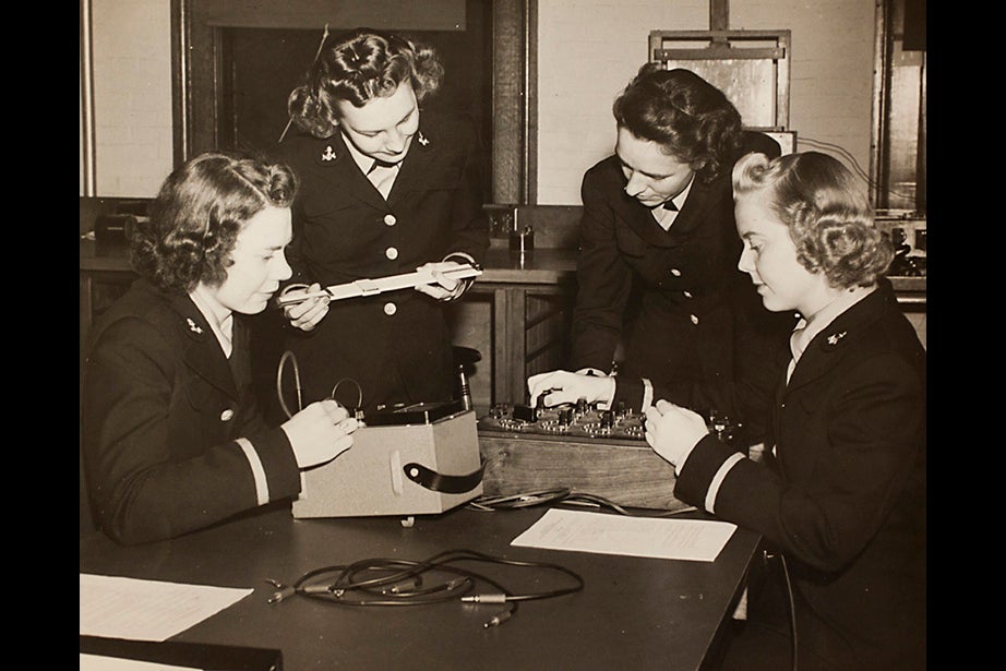 Copy image of historical material gathered from Harvard University Archives regarding the university's history with ROTC. Inscription on image verso reads, Navy, L to R, Ensigns E. Schwerin, Norma Meyer, Olga Quadland, and Edith Paulsen, Engineering 263-5 Course at Pierce Hall, October 23, 1943. Stephanie Mitchell/Harvard Staff Photographer