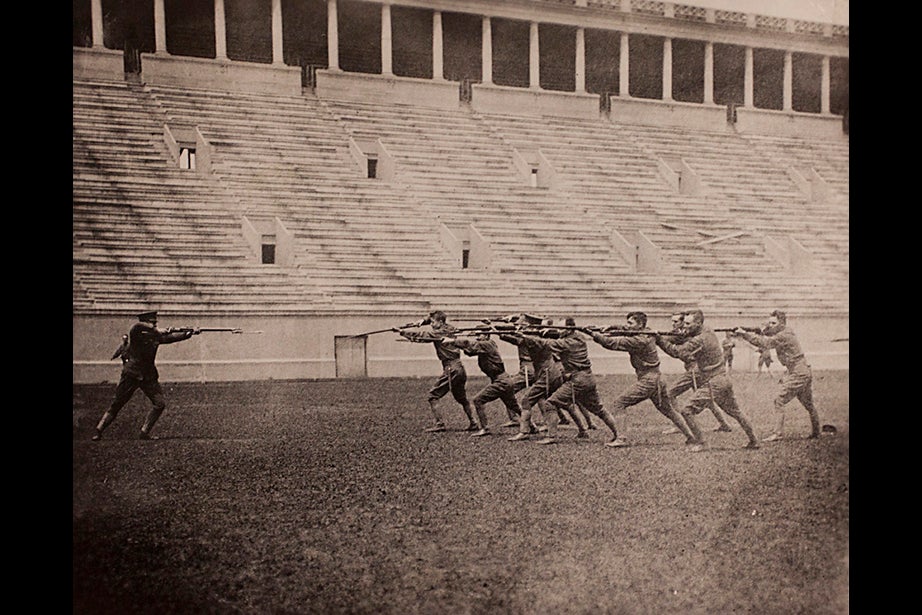 Copy image of historical material gathered from Harvard University Archives regarding the university's history with ROTC. The image inscription reads, Bayonet Drill, Harvard ROTC at Stadium, 1917-1918. Stephanie Mitchell/Harvard Staff Photographer