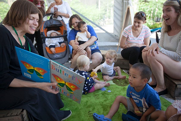 Cambridge Public Library's Youth Services Manager Julie Roach (left) reads at the Harvard Farmers' Market.