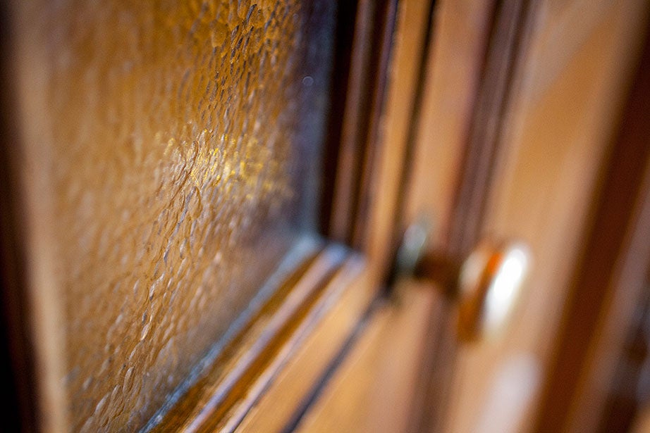 Textured gold-colored glass is framed inside two oak doors on the third floor of the chapel. 