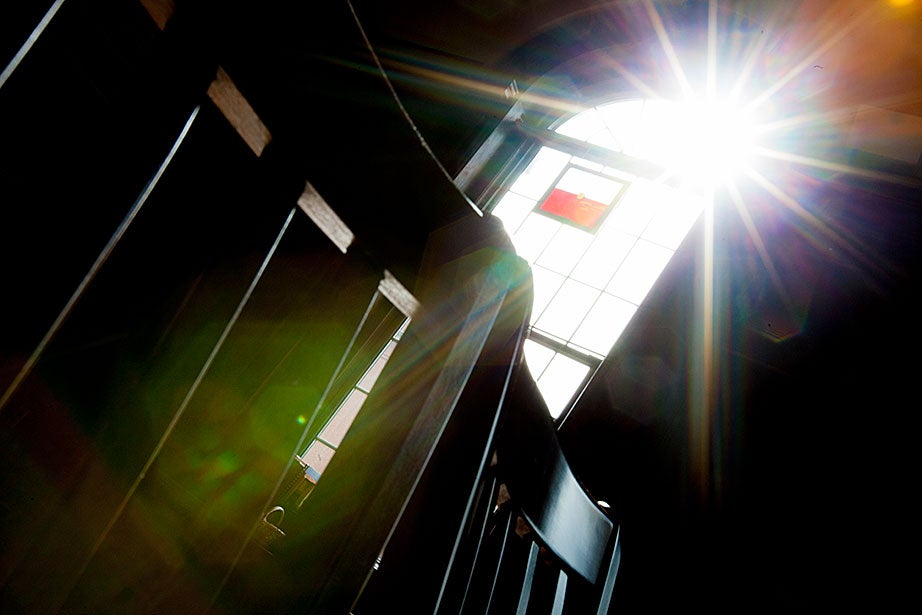 A starburst of light shines through a window in Divinity Hall.