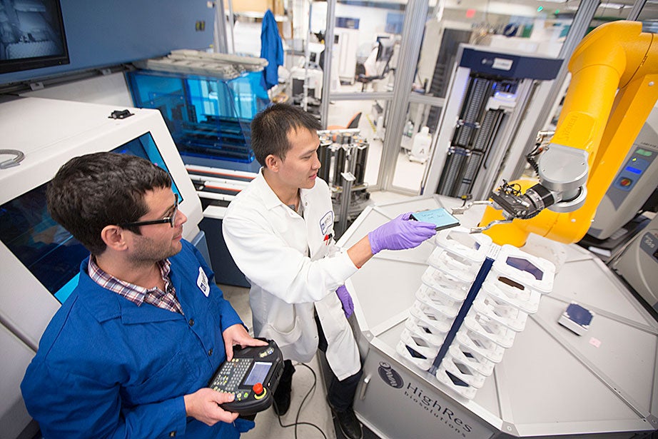 Broad Institute automation engineer Christian Soule (left) and research associate Hoang Danh perform high-throughput screening and compound management investigating cancer, infectious diseases, pesticide, and bacteria. 