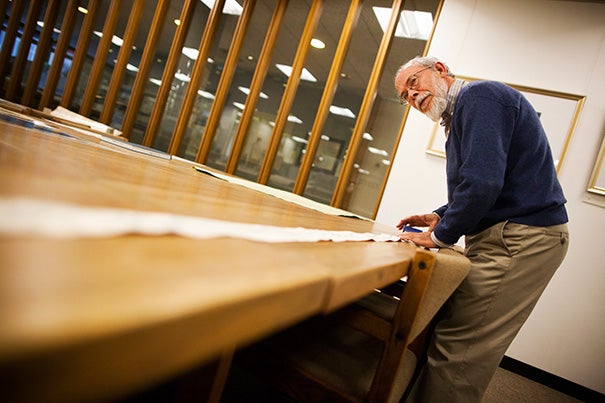 Research librarian Joseph Garver unrolls a Chinese scroll map from 1865, the longest in the collection. It was purchased by John King Fairbank, Harvard's first full-time professor of Chinese history. 