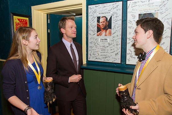 Hasty's Man of the Year Neil Patrick Harris (center) toured the Hasty Pudding Institute on Winthrop Street. The tour offered photos of past recipients of the Pudding Pot, including Bruce Willis. Leading the tour were Chaffee Duckers '16 (left) and Robert Fitzpatrick '16. Harris with his own Pudding Pot (photo 2).