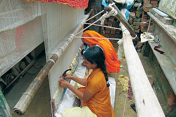 Carpet-making in India remains largely a cottage industry, with production in thousands of locations, from rural huts to makeshift factories (photos 1, 2). The carpet workers, who  toil 10 to 12 hours a day, six or seven days a week, often sleep in the shop, where they work on giant looms (photo 3). [Note: Faces have been blurred to protect identities.]