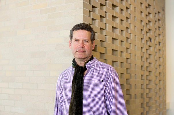 Christopher E.G. Benfey stands before the Harkness Commons wall designed by his great-uncle, Josef Albers.