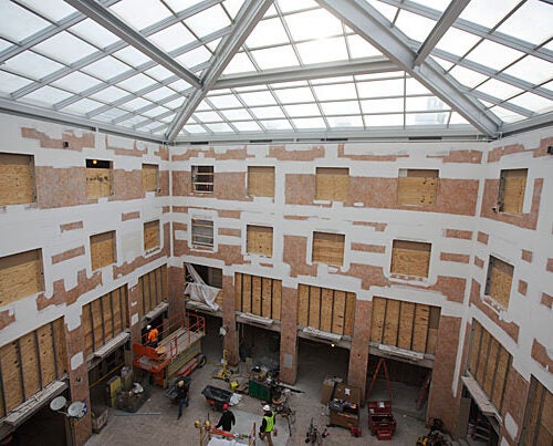 Workers renovate the Inn at Harvard as part of the House renewal and swing space projects (photos 1, 2). An artist's rendering shows what the atrium will look like upon completion (image 3).