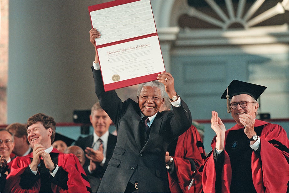 South African President Nelson Mandela holds aloft his honorary degree at a special convocation in his honor in 1998. Mandela was an anti-apartheid revolutionary who became South Africa's first black president after serving 27 years in prison under the white apartheid government. Photo by Mike Quan 