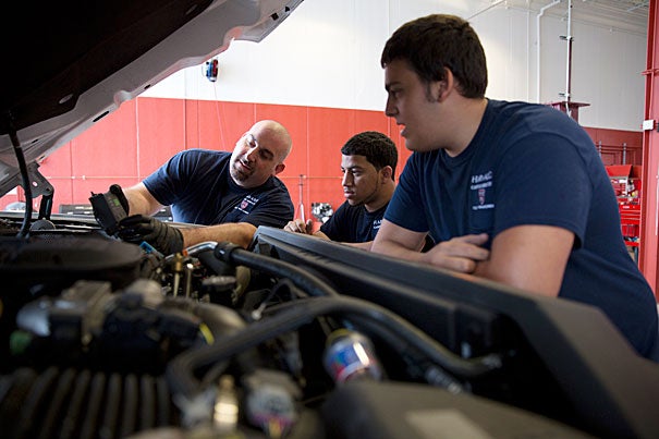 Harvard fleet technician Luigi Criscuolo (left) works with summer interns Javon Santos (center) and Pasquale Fulginiti, who said the experience "has given me a glimpse of what to expect when I leave here to attend the Benjamin Franklin Institute of Technology, and ultimately begin my career in automotive services.”