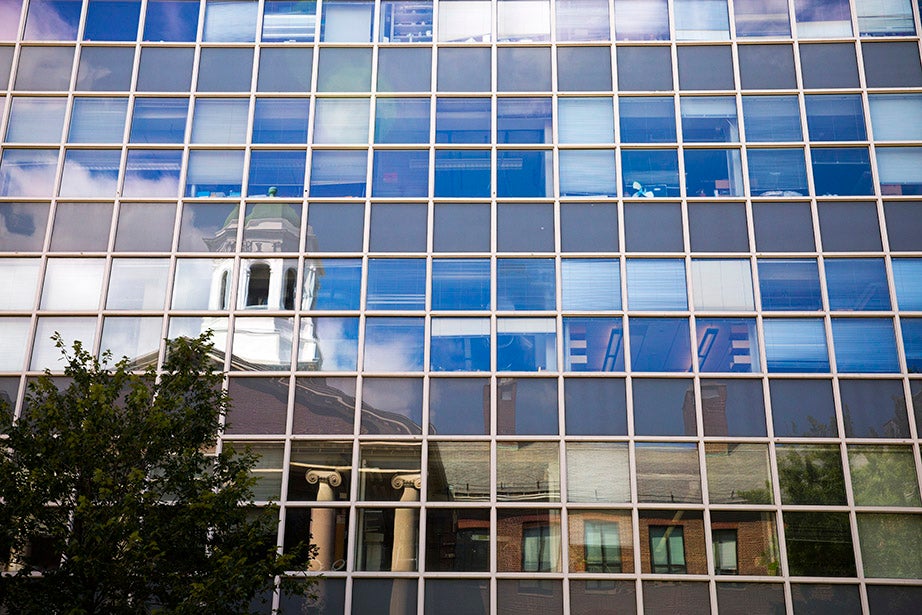 The tower on the Edward Mallinckrodt Chemical Laboratory (1929) on Oxford Street is reflected in the windows of the Gordon McKay Laboratory of Applied Sciences. 