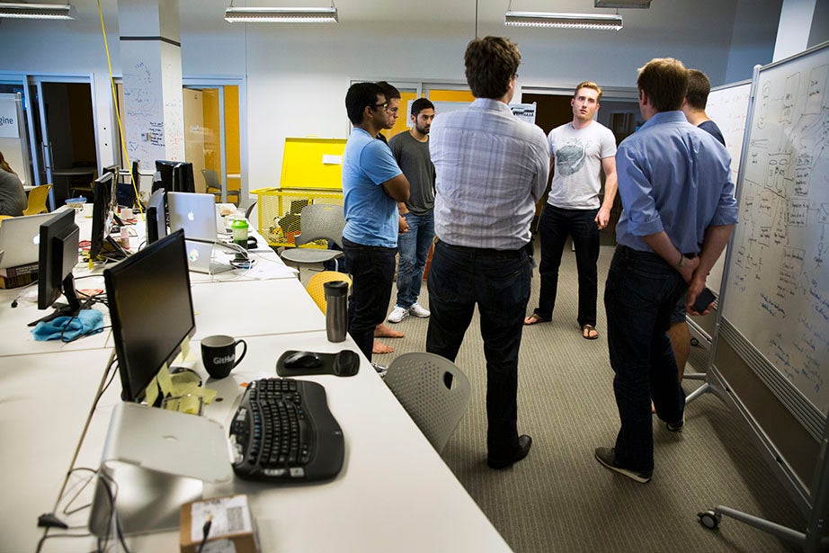 Joe Adelmann, a 2013 Harvard Kennedy School graduate (center), leads a morning meeting with the team from Censio, a usage-based insurance platform that enables auto insurers to reward customers who drive safely. 